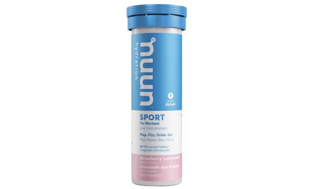 A cylindrical tube of Nuun Sport hydration tablets is shown. The packaging is blue and white with a pink section at the bottom. The label indicates the strawberry lemonade flavor and that there is zero sugar. The tube contains 10 tablets.