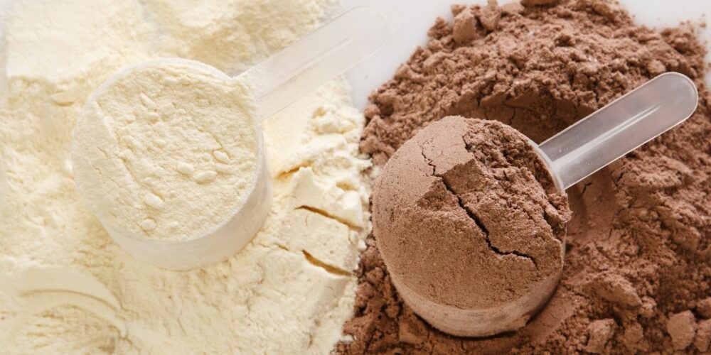 A close-up image showing two scoops of powder. The scoop on the left contains light-colored powder, while the scoop on the right contains dark brown powder. Both powders are placed on matching piles of their respective colors.