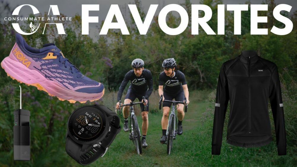 The image shows a collage with "FAVORITES" in large text at the top. It includes a pair of purple and pink Hoka shoes, a black Garmin smartwatch, a black jacket, and two cyclists in black kits riding bikes on a grassy trail.